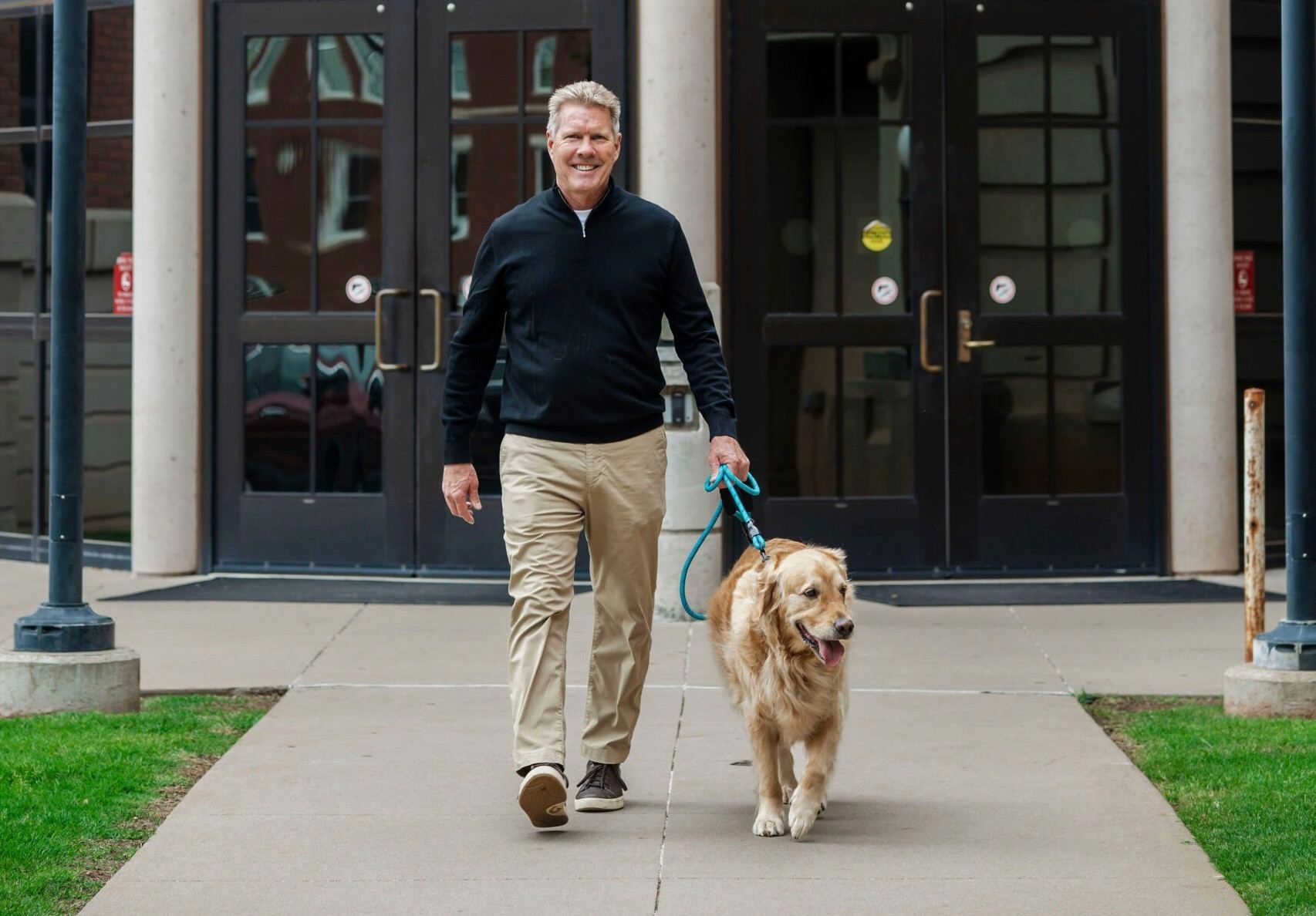 Michael Coulson walking his golden retriever outside the courthouse